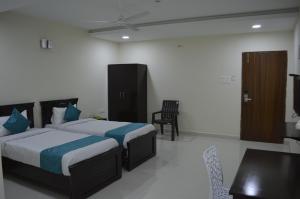 a hotel room with two beds and a table and chairs at HOTEL VIRAT INN in Hyderabad