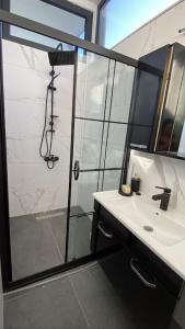 a bathroom with a shower and a sink and a mirror at Villa Camgüzeli Kivili Konak’ta! in Fethiye