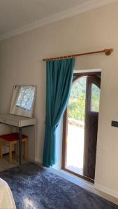 a bedroom with a blue curtain and a window at Villa Camgüzeli Kivili Konak’ta! in Fethiye