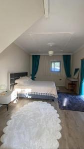 a bedroom with a bed and a white rug at Villa Camgüzeli Kivili Konak’ta! in Fethiye