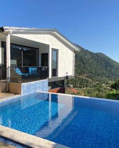 a swimming pool in front of a house at Villa Camgüzeli Kivili Konak’ta! in Fethiye