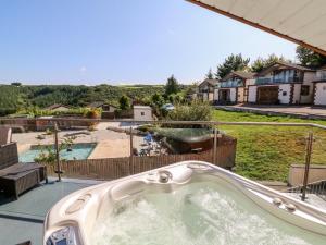 bañera con vistas a un patio trasero en Hazelwood Lodge, en High Bickington