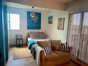 1 dormitorio con cama y sofá en Joli studio près du front de mer, en Cabourg