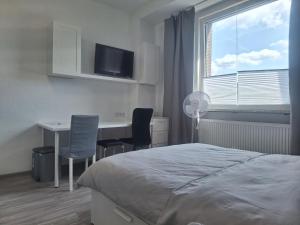 Schlafzimmer mit einem Bett, einem Schreibtisch und einem Fenster in der Unterkunft Apartment 16 - 2R1 in Essen
