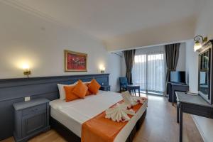 - une chambre avec un grand lit et des oreillers orange dans l'établissement Sapphire Club Hotel, à Bodrum City