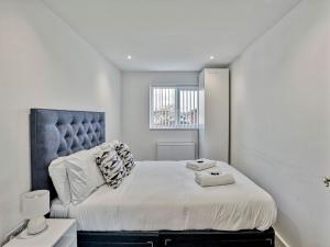 a bedroom with a large bed with a blue headboard at Pass the Keys Modern 3 Bed House Near Etihad Stadium in Manchester