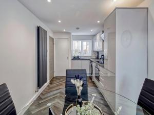 a kitchen with a glass table and a dining room at Pass the Keys Modern 3 Bed House Near Etihad Stadium in Manchester