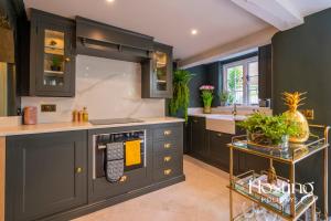a kitchen with gray cabinets and a sink at The Palm Retreat Marlow in Marlow