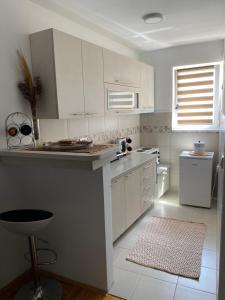 eine Küche mit weißen Schränken und einer Arbeitsplatte in der Unterkunft MKA suite in Kragujevac