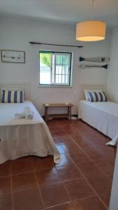 Camera con 2 letti e pavimento piastrellato. di Casa Melides a Melides