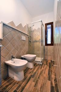 a bathroom with a toilet and a sink and a shower at Gli Olivastri Guest House in Arzachena