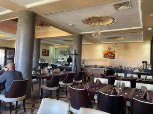 a restaurant with tables and chairs and a bar at Palais Du Desert Hotel & Spa in Erfoud
