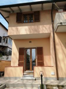 una casa con una escalera que conduce a la puerta principal en Maresol apartment, en Carrara