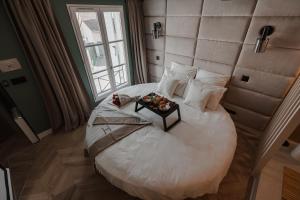 a bedroom with a large white bed with a table on it at DISNEY MOOD BY WELOVEYOU® in Bailly-Romainvilliers