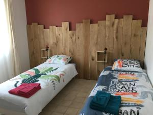1 Schlafzimmer mit 2 Betten und einer Holzwand in der Unterkunft Maison de vacances au calme in Angles