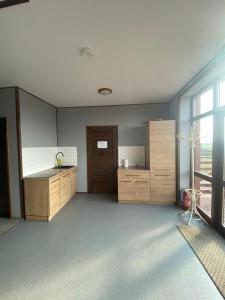 una cocina con armarios de madera y una gran ventana en Pensjonat Paskudy, en Paskudy