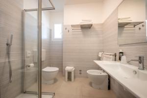 uma casa de banho com um lavatório, um WC e um chuveiro em Hotel Parigi em Caorle