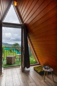 um quarto com uma grande porta de vidro deslizante e uma varanda em The Soul Stroll Cottages Retreat em Mukteshwar