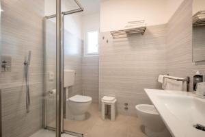 uma casa de banho com um WC, um lavatório e um chuveiro em Hotel Parigi em Caorle