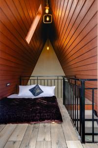 a bedroom with a bed with a wooden ceiling at The Soul Stroll Cottages Retreat in Mukteswar