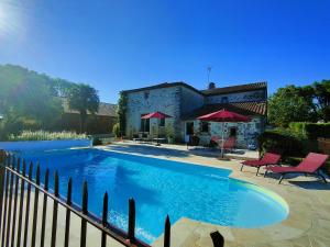 a swimming pool in front of a house at La Champrenière in Puy-du-Fou