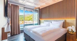 Un dormitorio con una cama grande y una ventana grande. en PLAZA Premium Heidelberg, en Heidelberg