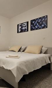 - une chambre avec un lit blanc et trois photos sur le mur dans l'établissement Cozy Hideaway, à Ljubljana