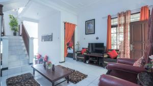 een woonkamer met een bank en een tv bij Villa Malang Puncak Buring in Malang +10 foto's