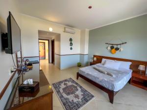 a bedroom with a bed and a flat screen tv at Club Red Dahab Motel in Dahab