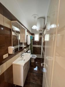 uma casa de banho com um lavatório branco e um WC. em Adriatik Guesthouse em Përmet