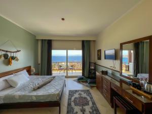 1 dormitorio con cama, espejo y balcón en Club Red Dahab Motel, en Dahab