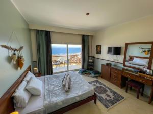 a bedroom with a bed and a desk and a mirror at Club Red Dahab Motel in Dahab