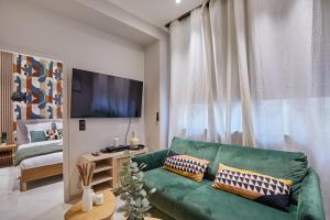 sala de estar con sofá verde y cama en Apartment Montmartre by Studio prestige, en París