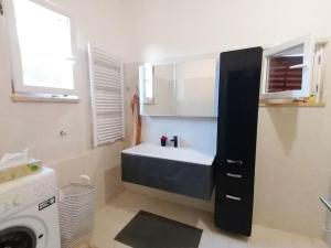 a bathroom with a sink and a washing machine at Villa Rapunzel in Brovinje