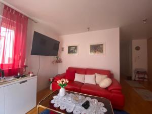 a living room with a red couch and a table at Cozy Room + shared kitchen + shared bathroom + free parking in Hvar