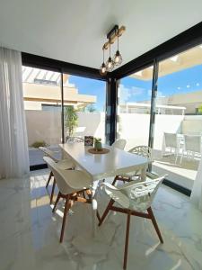 comedor con mesa blanca y sillas en Neubauvilla mit Pool Los Montesinos, en Los Montesinos