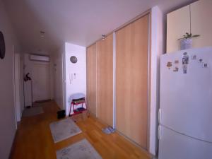 a room with a white refrigerator and a wooden door at Cozy Room + shared kitchen + shared bathroom + free parking in Hvar