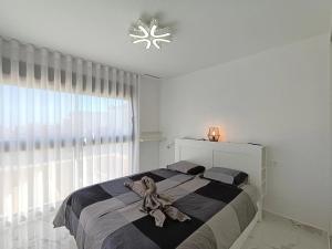 un dormitorio con un osito de peluche sentado en una cama en Neubauvilla mit Pool Los Montesinos, en Los Montesinos