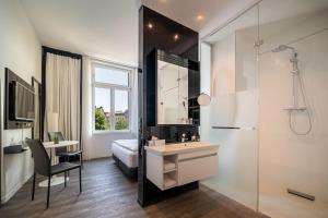 a bathroom with a bed and a sink and a mirror at INNSiDE by Meliá Leipzig in Leipzig