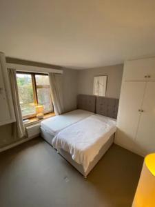 1 dormitorio con 1 cama blanca grande y ventana en Mulberry Barn located in the South Downs National Park en Ditchling