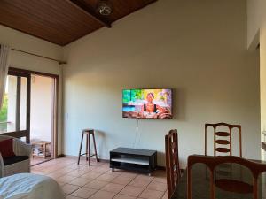 sala de estar con TV en la pared en Apartamento na praia de Taperapuan, en Porto Seguro