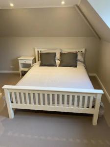 a white bed with two pillows on it in a room at Mulberry Barn located in the South Downs National Park in Ditchling