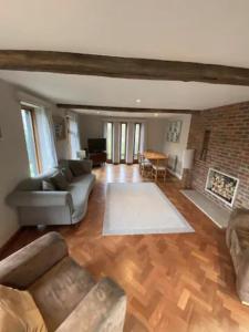 a living room with a couch and a fireplace at Mulberry Barn located in the South Downs National Park in Ditchling