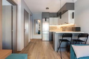 a kitchen and living room with a counter and chairs at Hippocrates bound by BiNoBi! in Thessaloniki +11 photos