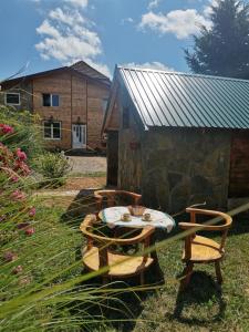 einen Tisch und Stühle in einem Hof mit einem Gebäude in der Unterkunft Bungalov Živković in Mojkovac