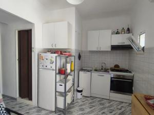 een keuken met witte kasten en een koelkast bij Spalato 7 HOWME in Bari