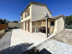 a building with a large patio in front of it at 2948-Maison 8 couchages 600m de la mer in Saint-Cyprien