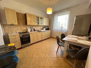 cocina con armarios de madera, mesa y encimera en Apartament #WIDOKOWA FV Parking Balkon, en Rzeszów