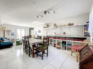 uma cozinha e sala de jantar com mesa e cadeiras em 2948-Maison 8 couchages 600m de la mer em Saint-Cyprien