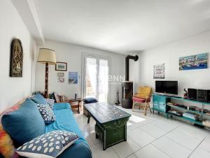 uma sala de estar com um sofá azul e uma mesa em 2948-Maison 8 couchages 600m de la mer em Saint-Cyprien